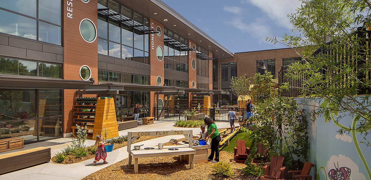 Photo of the YMCA, showing a courtyard with people walking and a two story building.